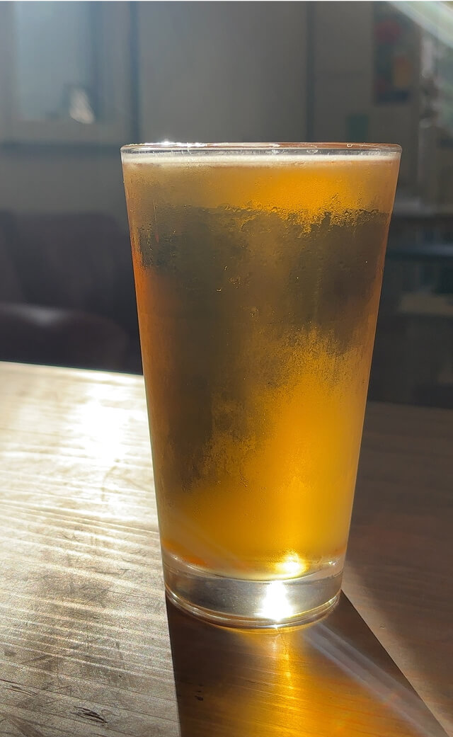 逆光を浴びるグラスに入ったビール
